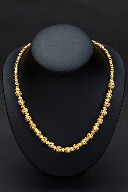 Beautiful golden necklace designed in Thai ancient pattern on the black stand